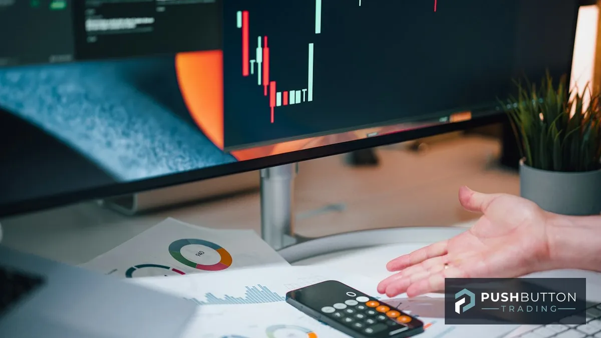 Trader reviewing printed performance charts and a candlestick chart monitor during a weekend bot portfolio review, Push Button Trading