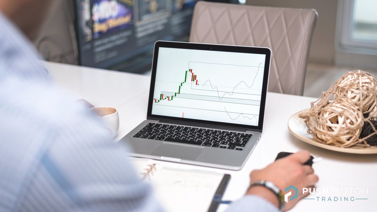 Trader reviewing a candlestick chart on a laptop at a bright office desk