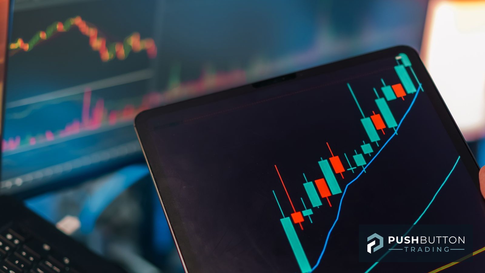 Trader reviewing a candlestick chart on a tablet beside a laptop trading platform