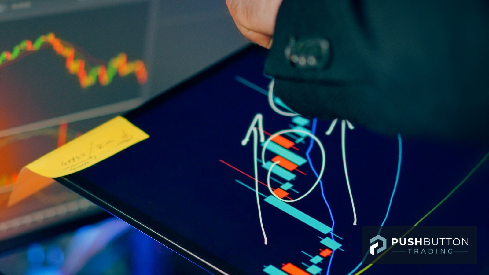 Trader pointing at a candlestick chart on a tablet with drawdown annotations, multi-monitor trading desk behind