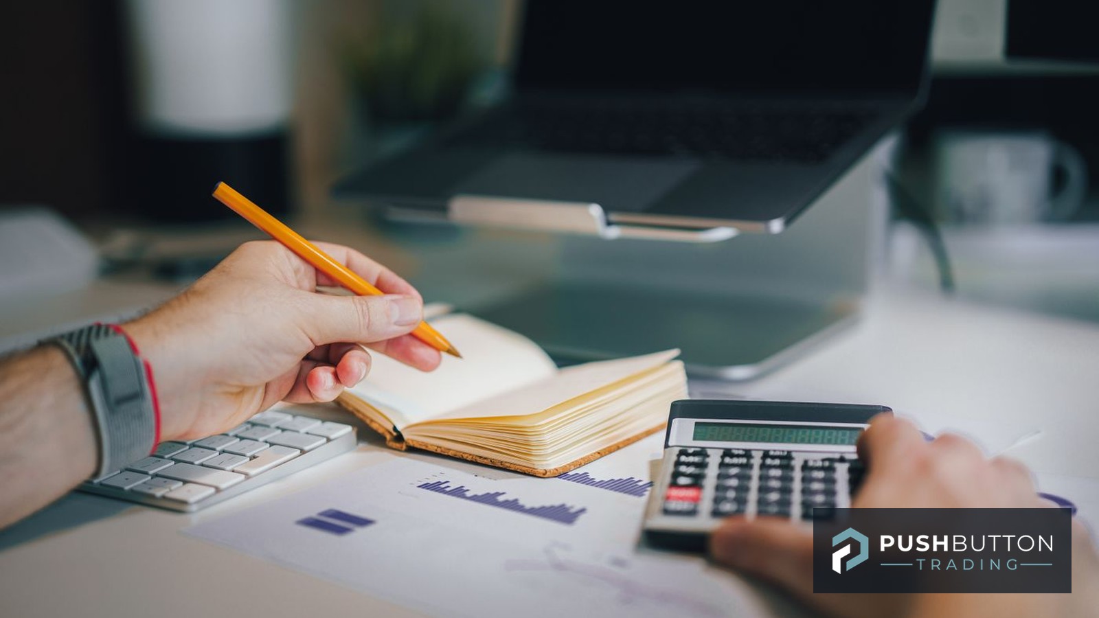Trader adding up funded-account costs with a calculator, notebook and printed performance charts