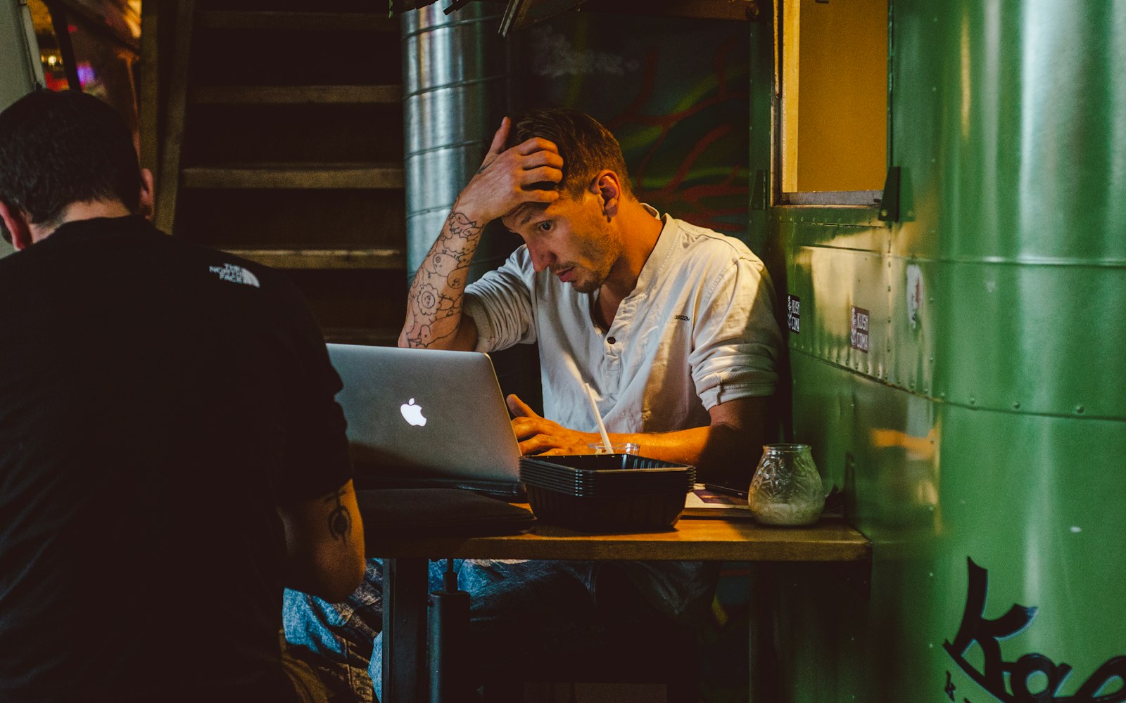 Stressed trader holding his head while staring at a laptop