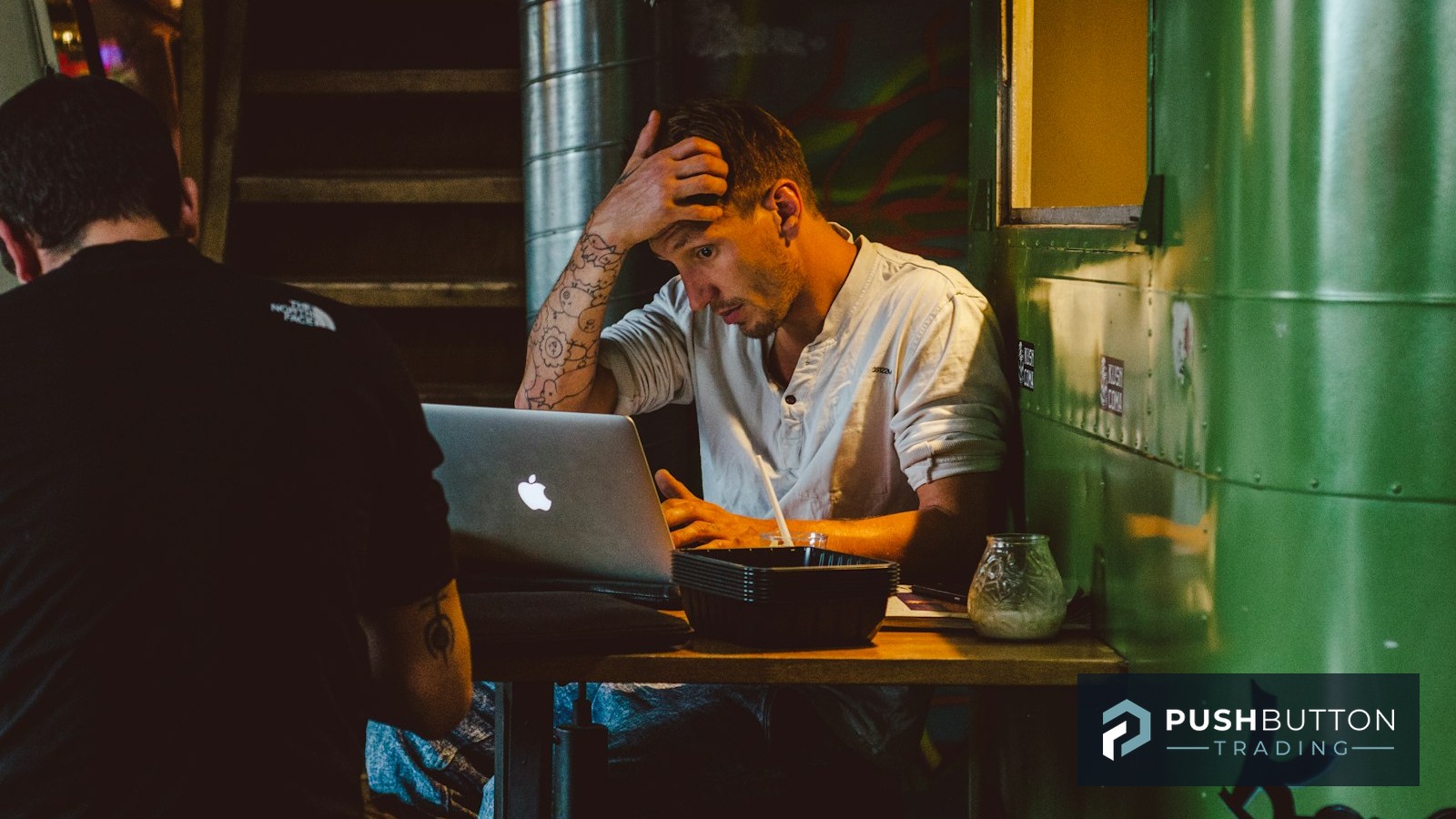 Stressed trader holding his head while staring at a laptop