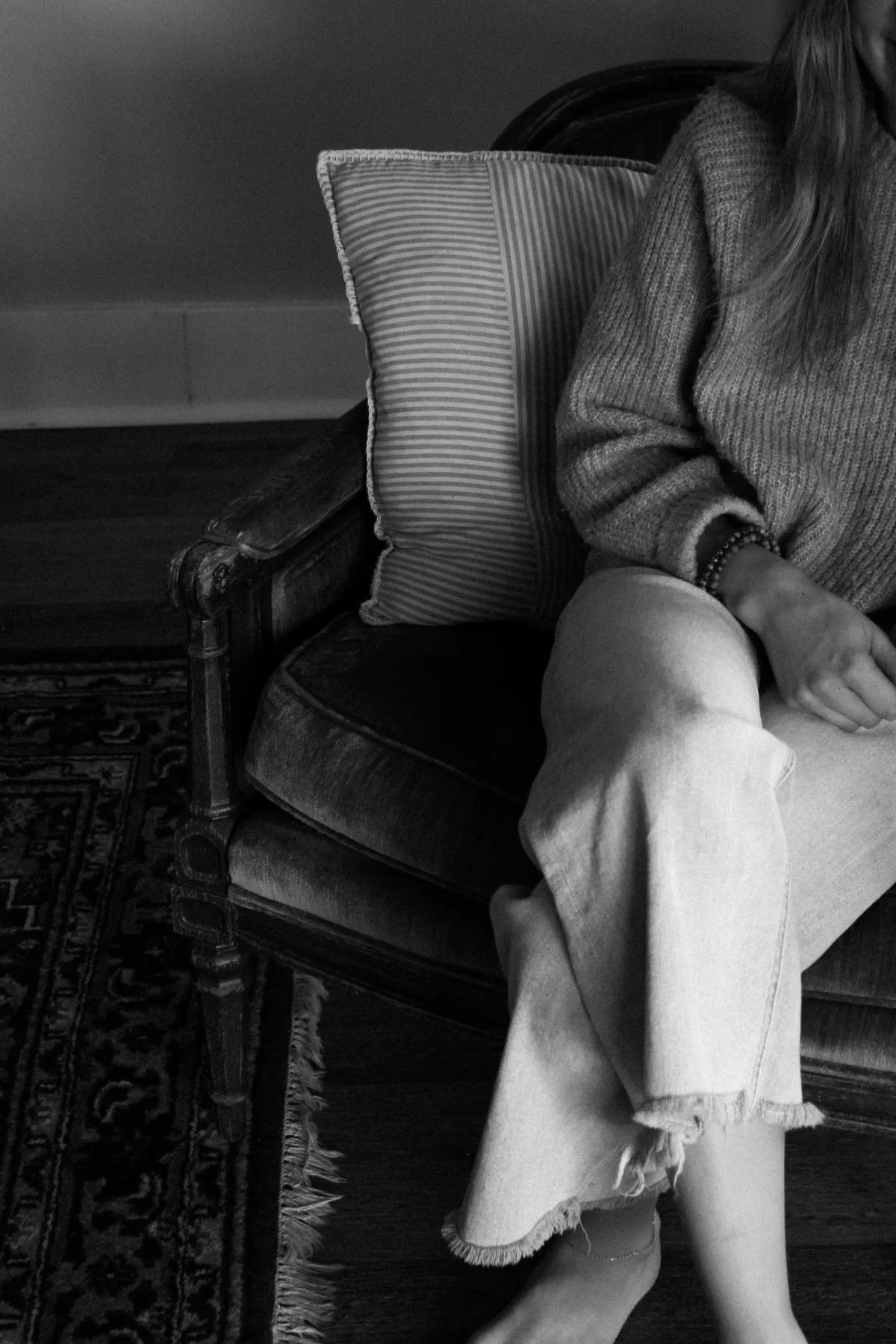 black and white photo of a women sitting in a chair