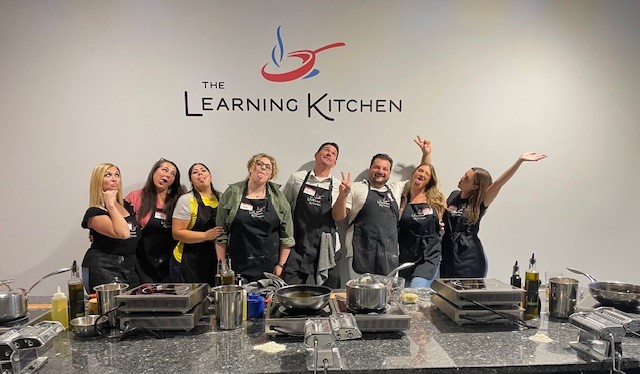 Friends enjoying a fun hands-on group cooking class and gourmet dining experience