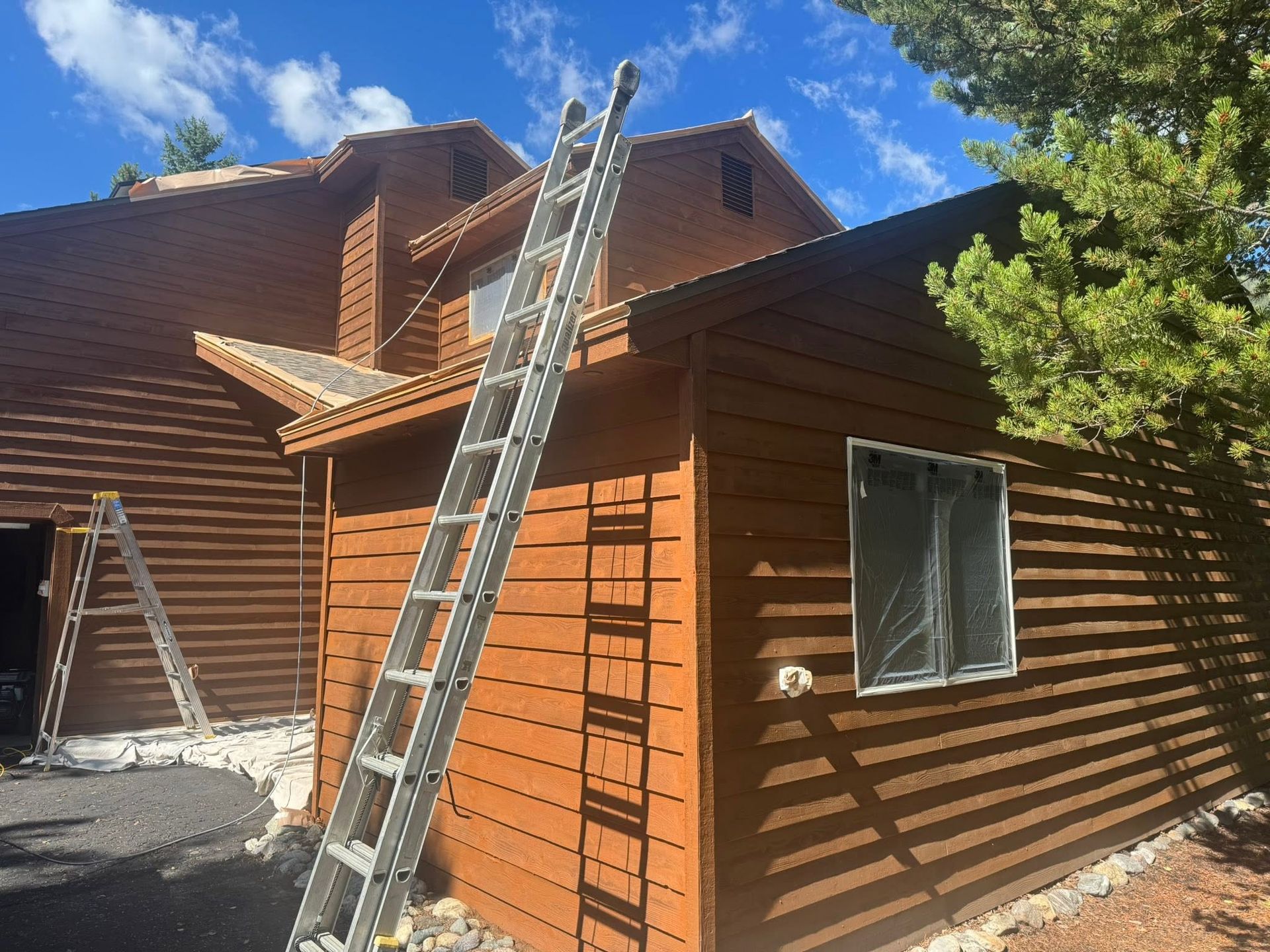 A two-story house with blue siding, white trim, and a white garage door.