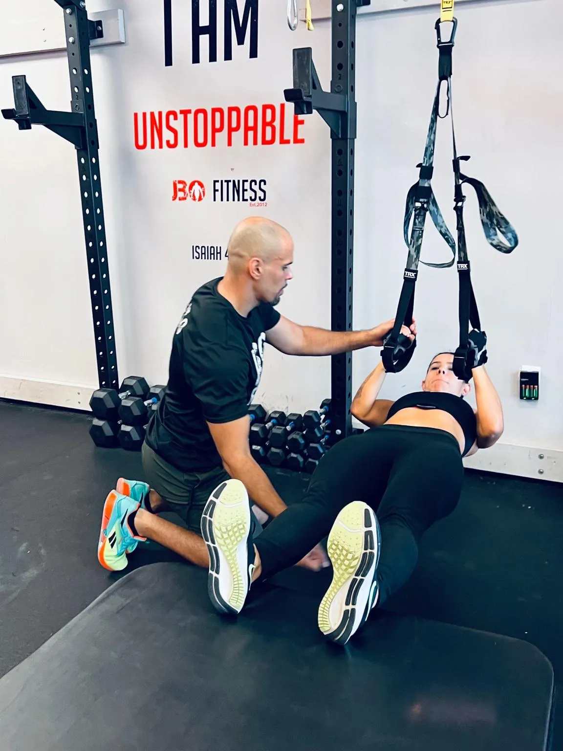 Coach Johnny guiding a client in a group personal training session at JBoFitness