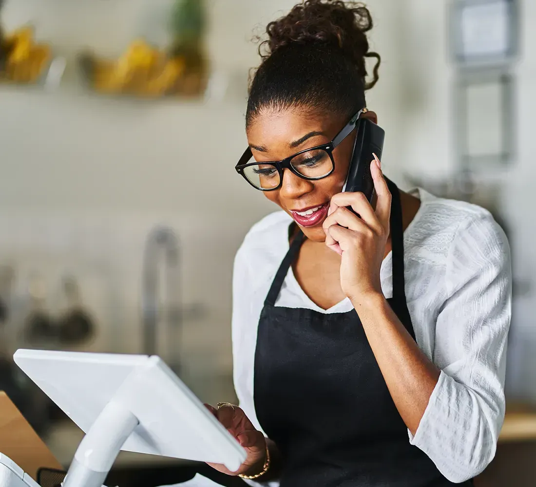 Minimalist, modern workspace with a diverse local business owner reviewing marketing analytics on a sleek laptop, soft daylight, clean lines, neutral palette, 3:2 aspect ratio