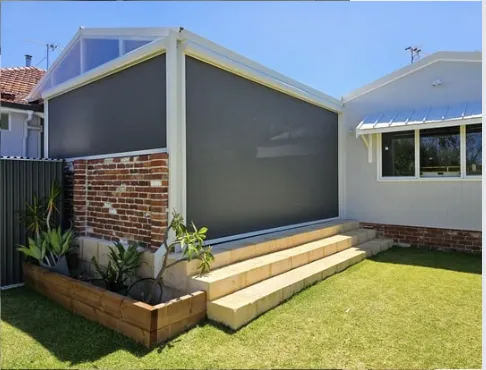 Black zip screen roller blind providing shade and privacy on a modern home.