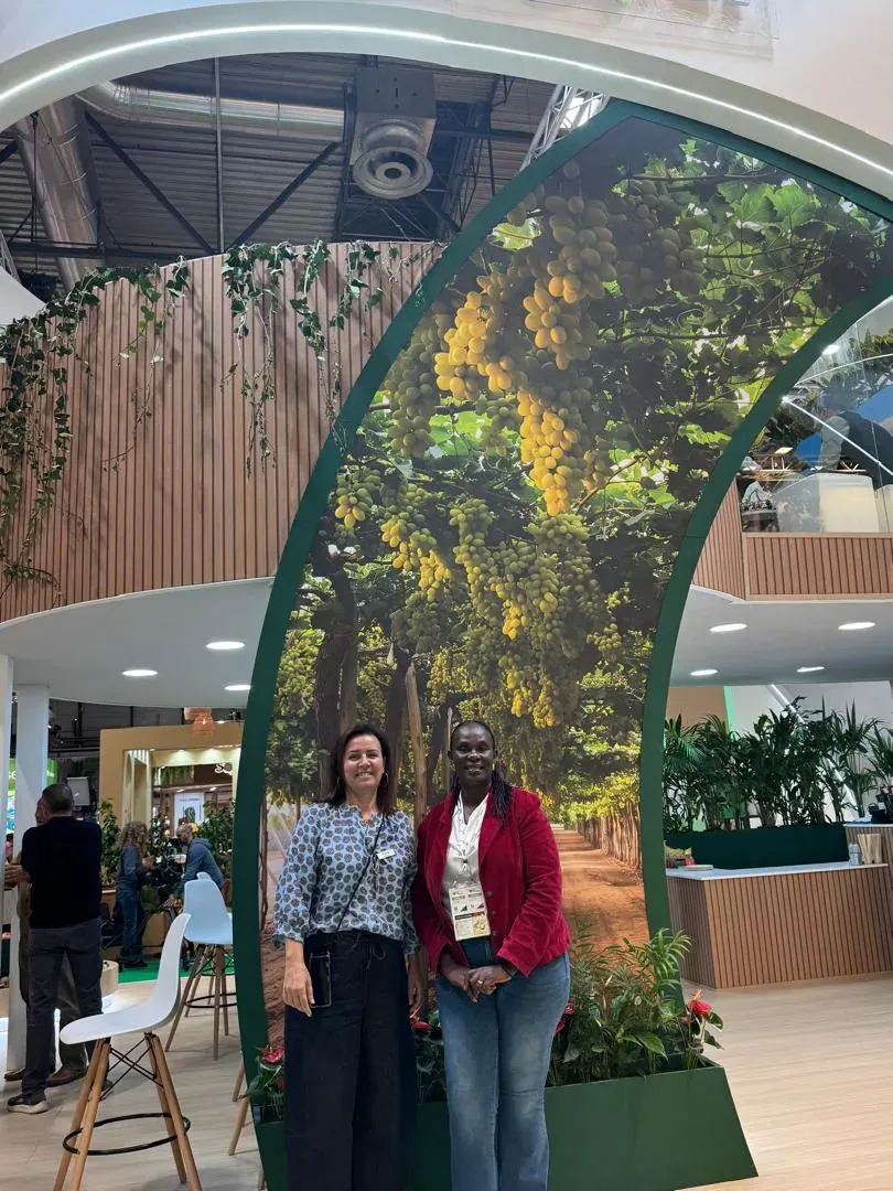Betty Kabahenda of Mashamba under a large table grape display at Fruit Attraction 2026 in Madrid