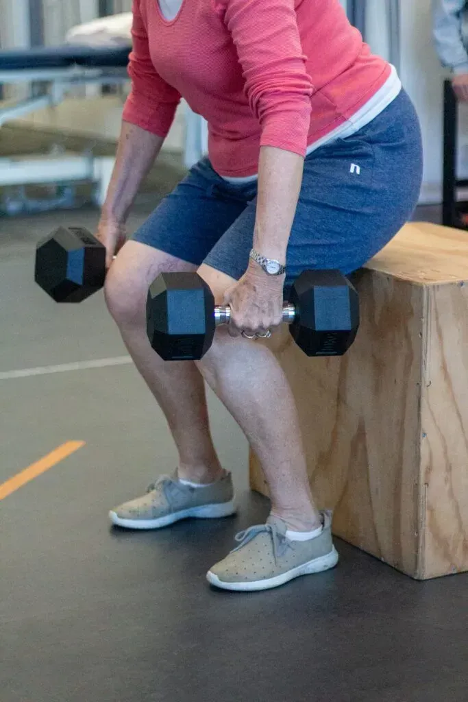 1. “Physiotherapist coaching an older adult through a supported squat as part of an exercise program for knee arthritis on the Gold Coast”