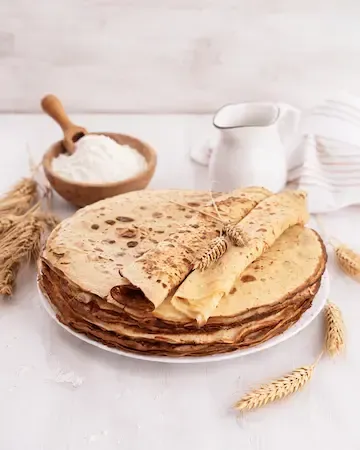 Pile de crêpes maison dorées, servies dans un esprit traditionnel à la Crêperie La Sarrasine à Versailles.