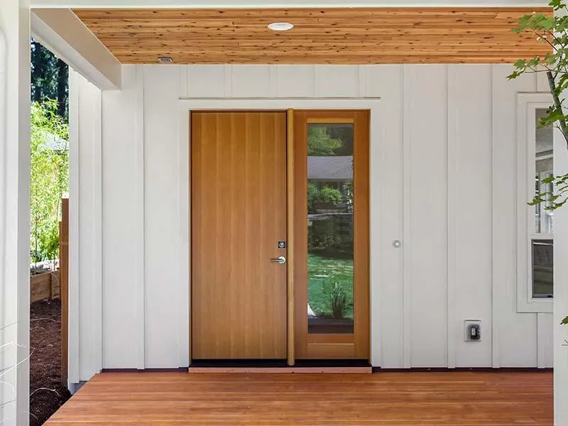 a wooden door with white siding