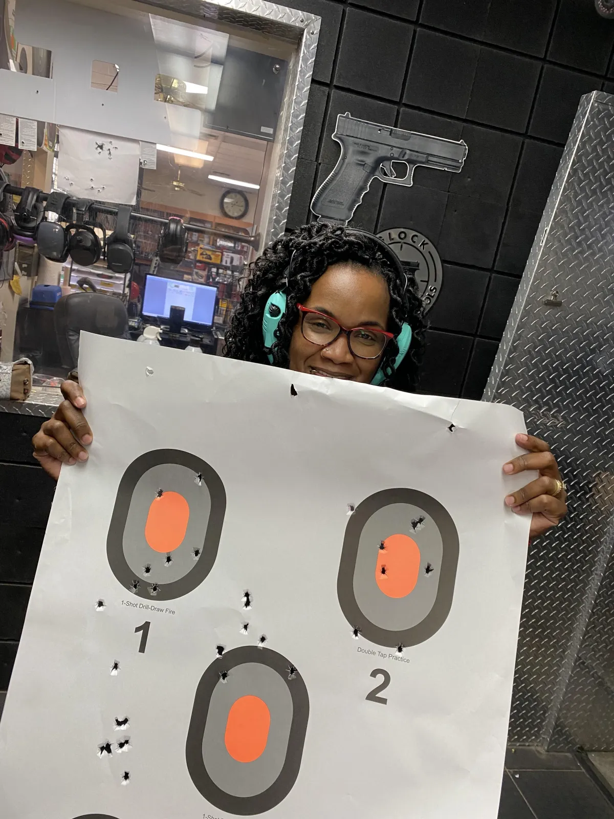 black female beginners guide to firearms student showing her target at the range