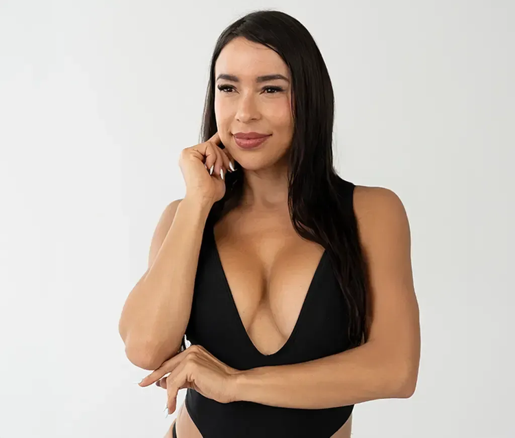 a pink flower with green leaves in the background