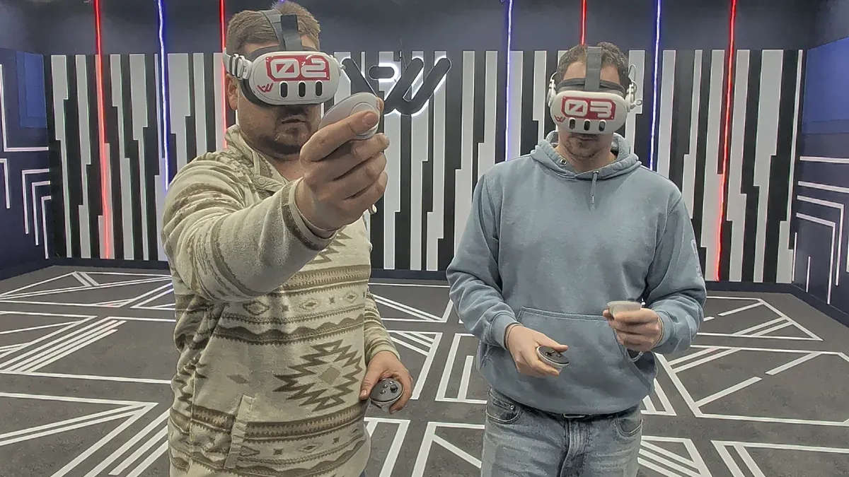 Two players in VR headsets side by side in the Another World VR arena in Aldergrove