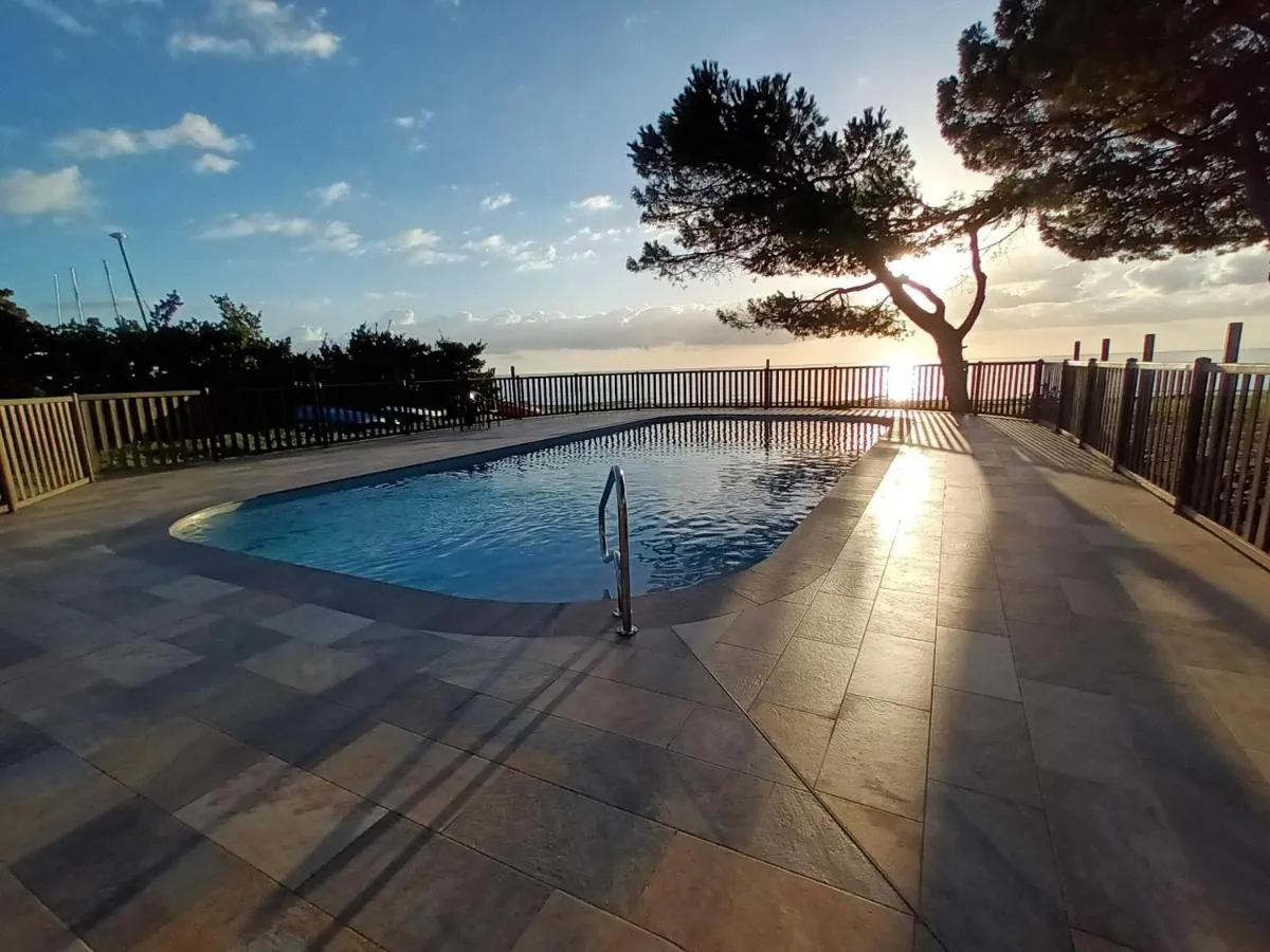 Piscine du domaine face à la mer au coucher du soleil