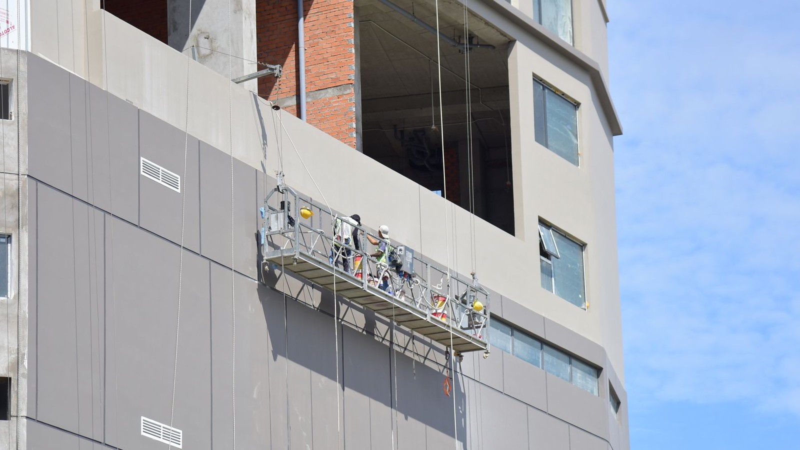 Why Painting a 15-Story Tower Isn't a Painting Job: Swing Stages, Wind Windows, and What Your Bid Should Include