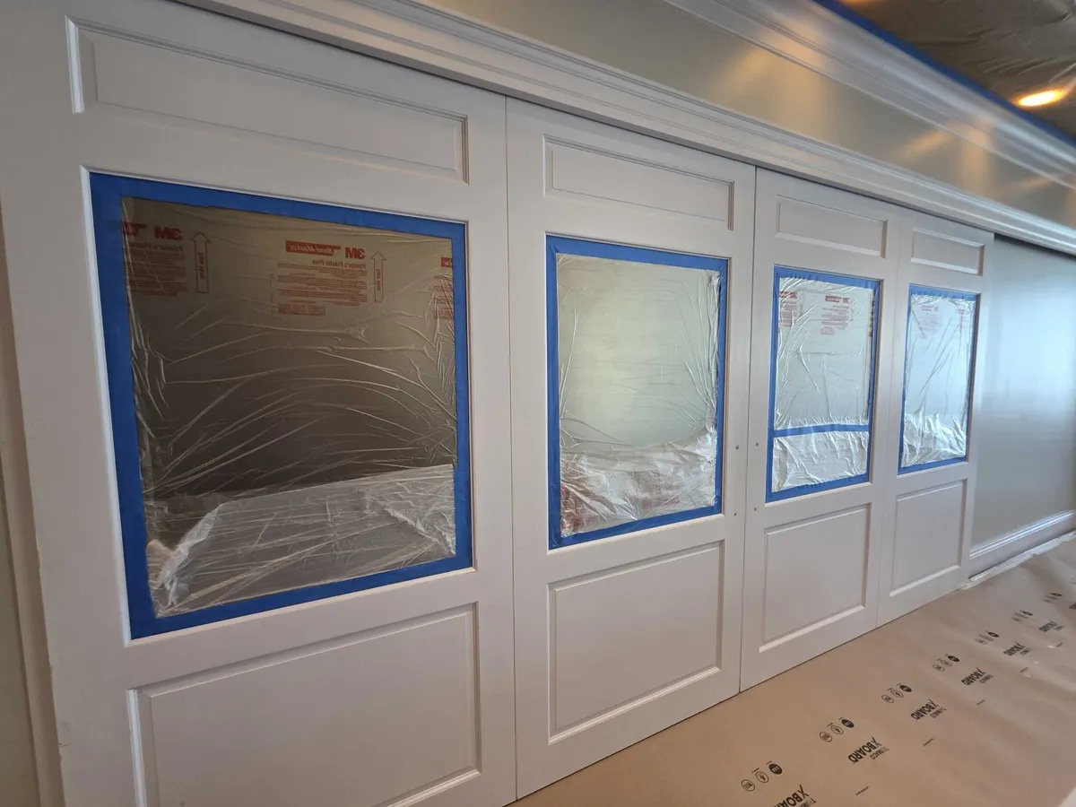 Windows masked with tape before painting at Pelican Isles Yacht Club