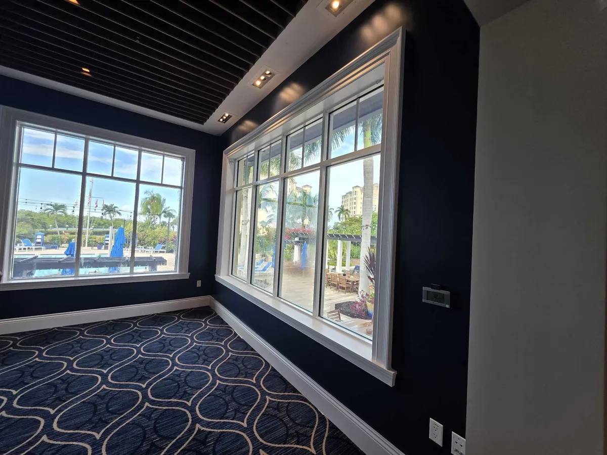 Navy accent walls and white window trim during repainting at Pelican Isles Yacht Club