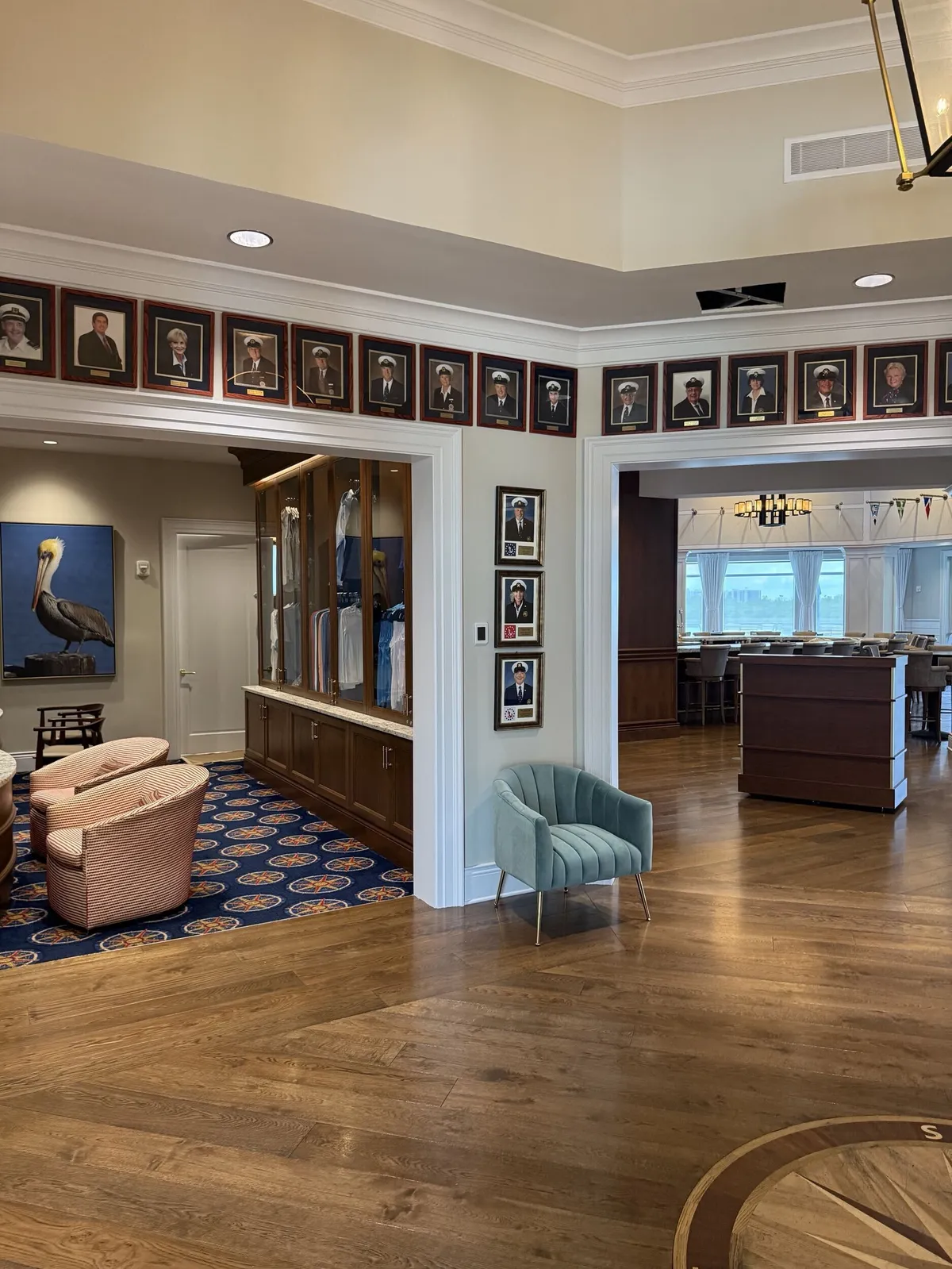 Repainted clubhouse lounge and hallway with framed photos at Pelican Isles Yacht Club