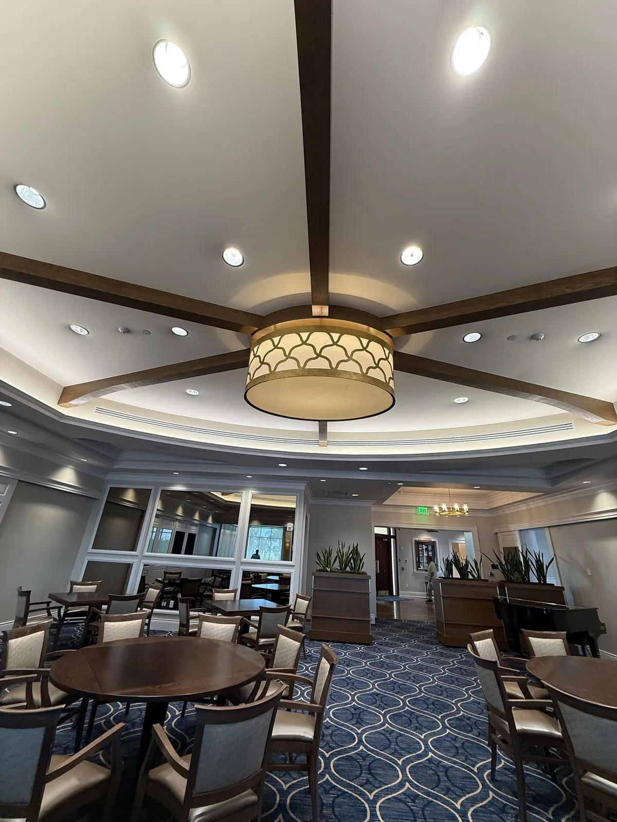 Repainted dining room ceiling with wood beams and drum chandelier at Pelican Isles Yacht Club