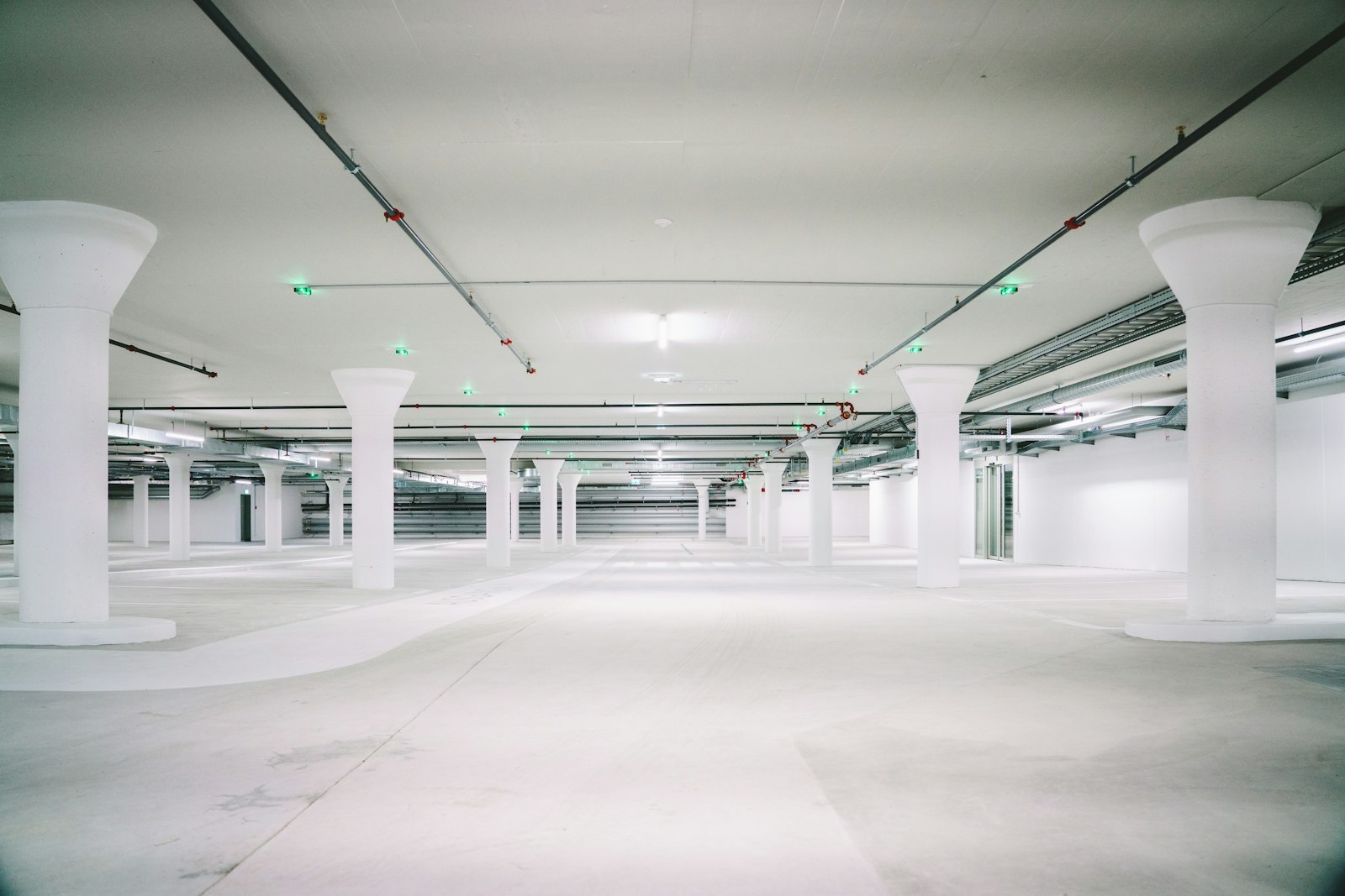 Empty below-grade concrete parking garage with rows of structural support columns, representative of the coastal Florida structures that need coordinated sealant and membrane waterproofing