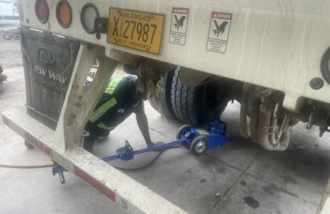 Trailer raised on a floor jack for tire and lube service
