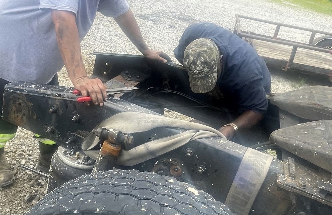 Mechanics repairing a trailer undercarriage on-site