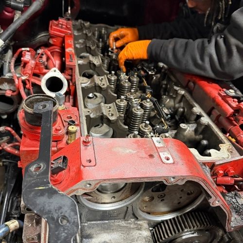 Mechanic rebuilding a red diesel engine cylinder head