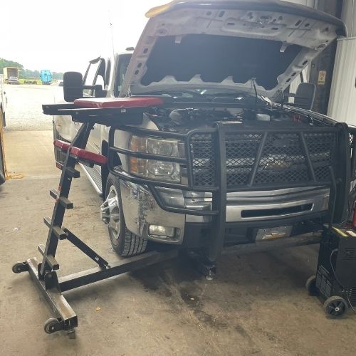 Heavy-duty pickup with the hood open for engine service in the shop
