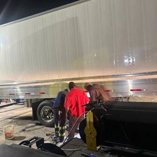 Crew working on a semi-trailer at a truck stop