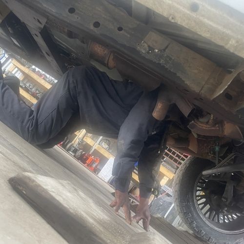 Mechanic crawling under a heavy truck to inspect the undercarriage