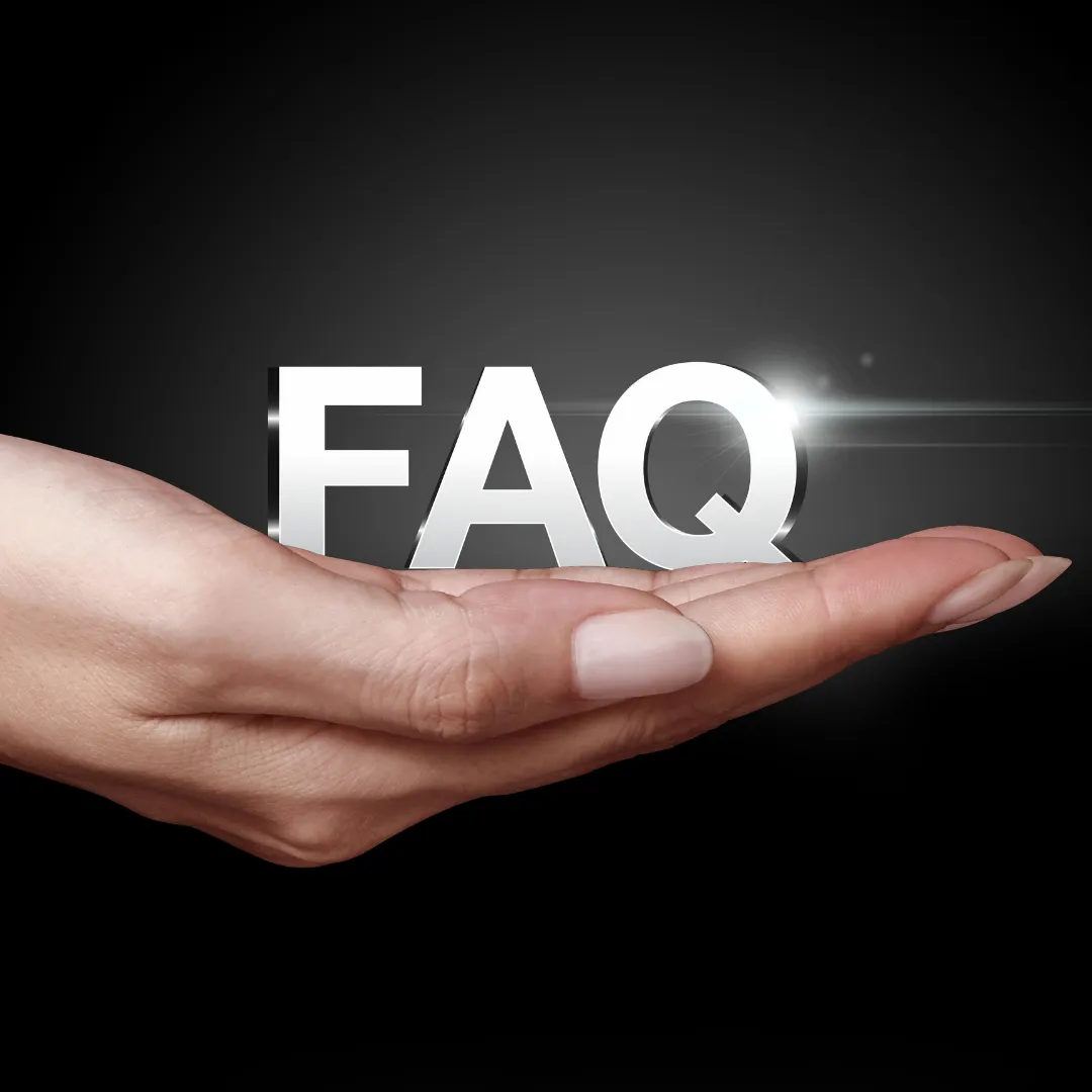 A hand gently holding large, glowing silver letters spelling ‘FAQ’ against a dark black background, symbolizing support and answers to frequently asked questions.