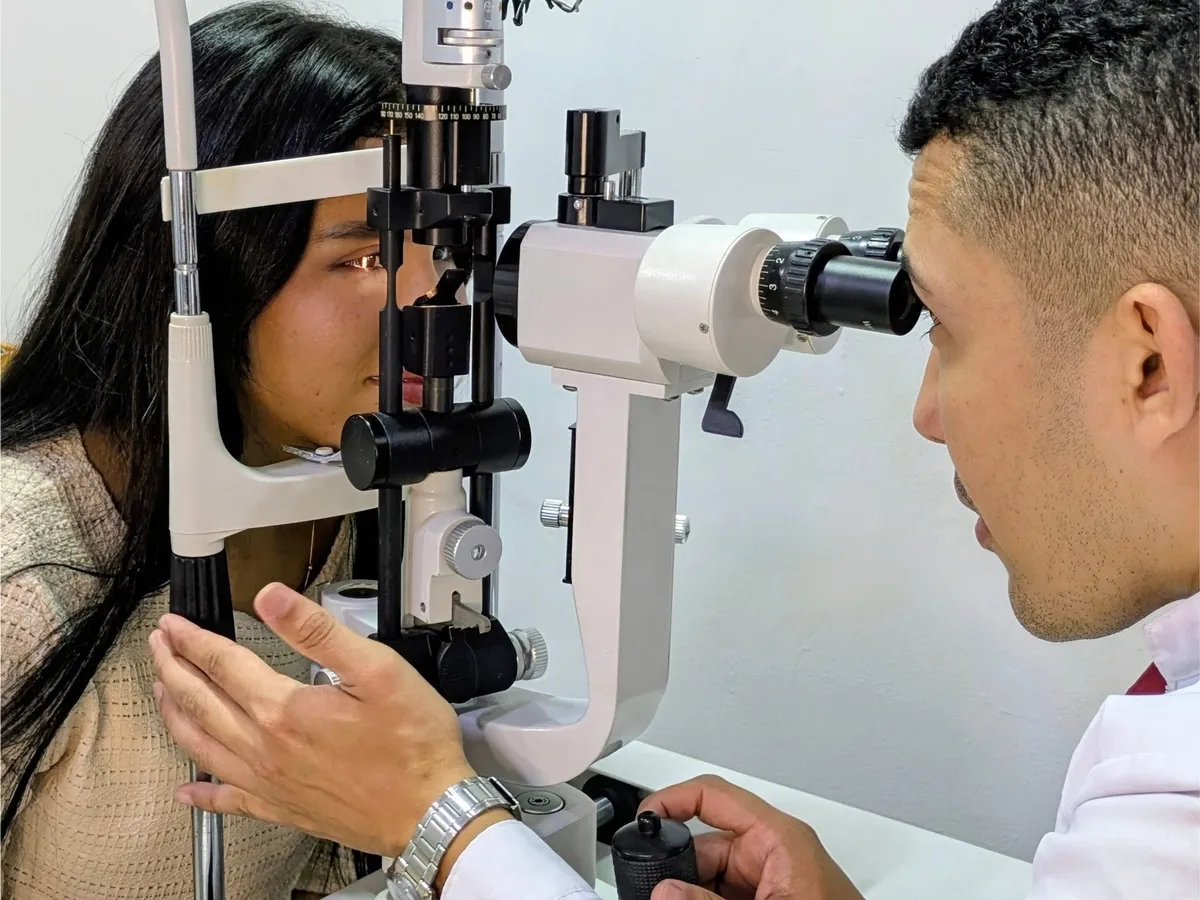 Female optician or optometrist examining optical lenses in a well-lit clinical environment