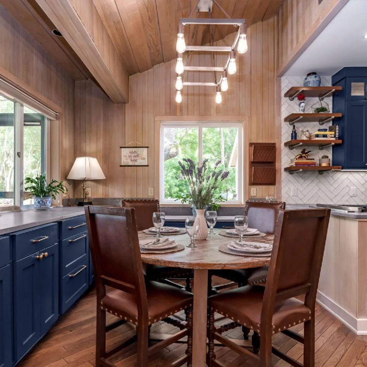 Cozy dining nook with wood table, blue cabinetry, and pendant lighting