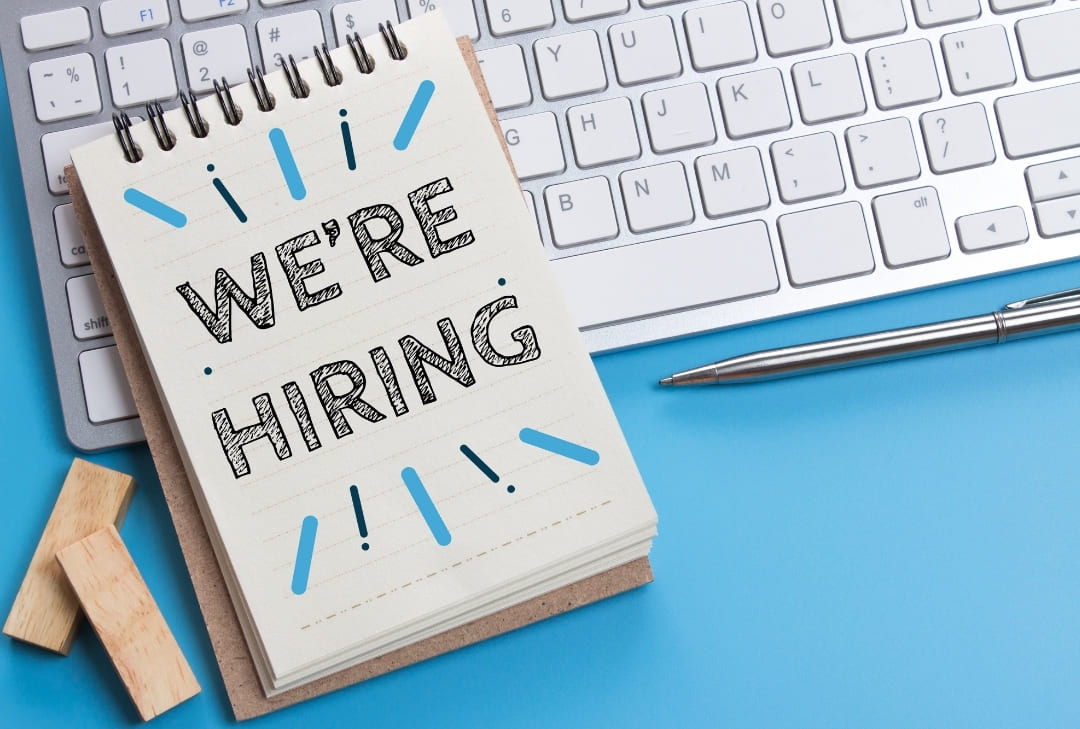 note pad with the words "we're hiring" written on it