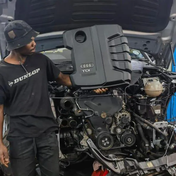 Professional RevLine Auto master mechanic holding diagnostic scanner in workshop bay