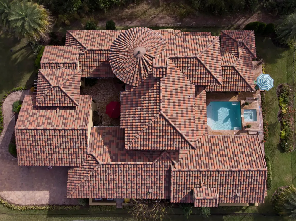 a red car parked on top of a roof next to a body of water
