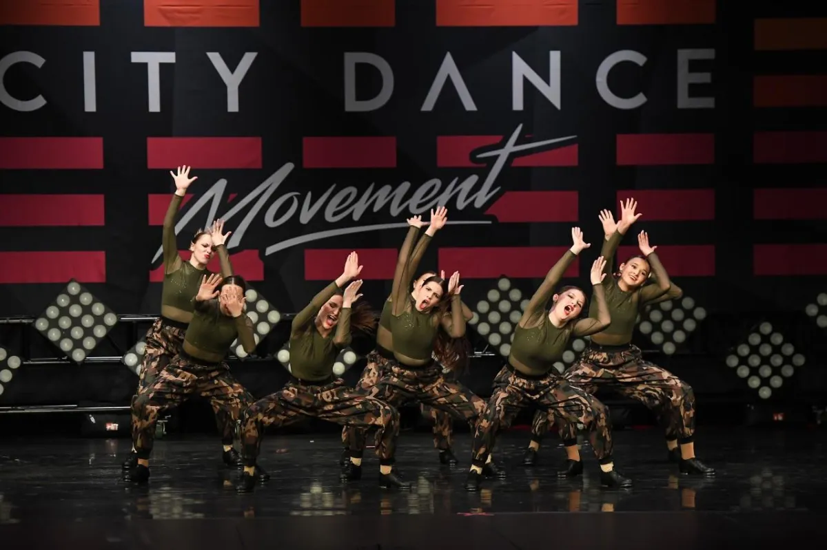 Dancers in green and camoflage costume on stage