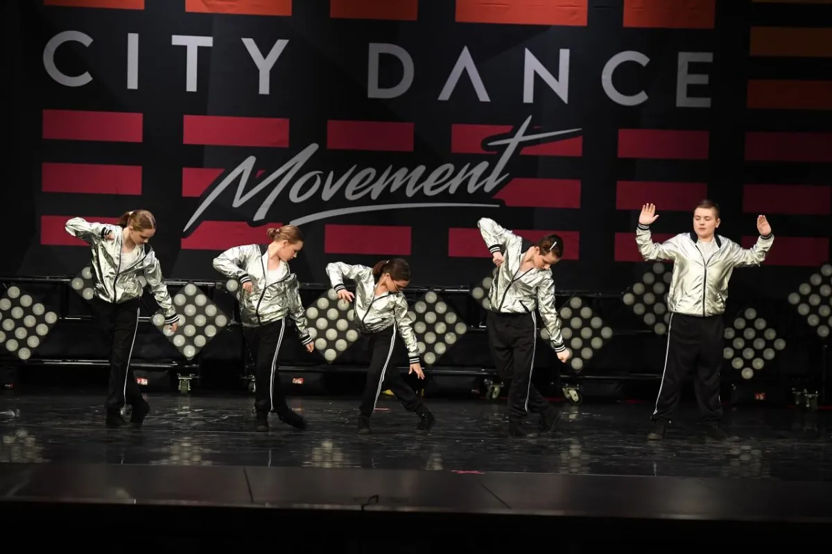 Dancers in silver and black costume on stage