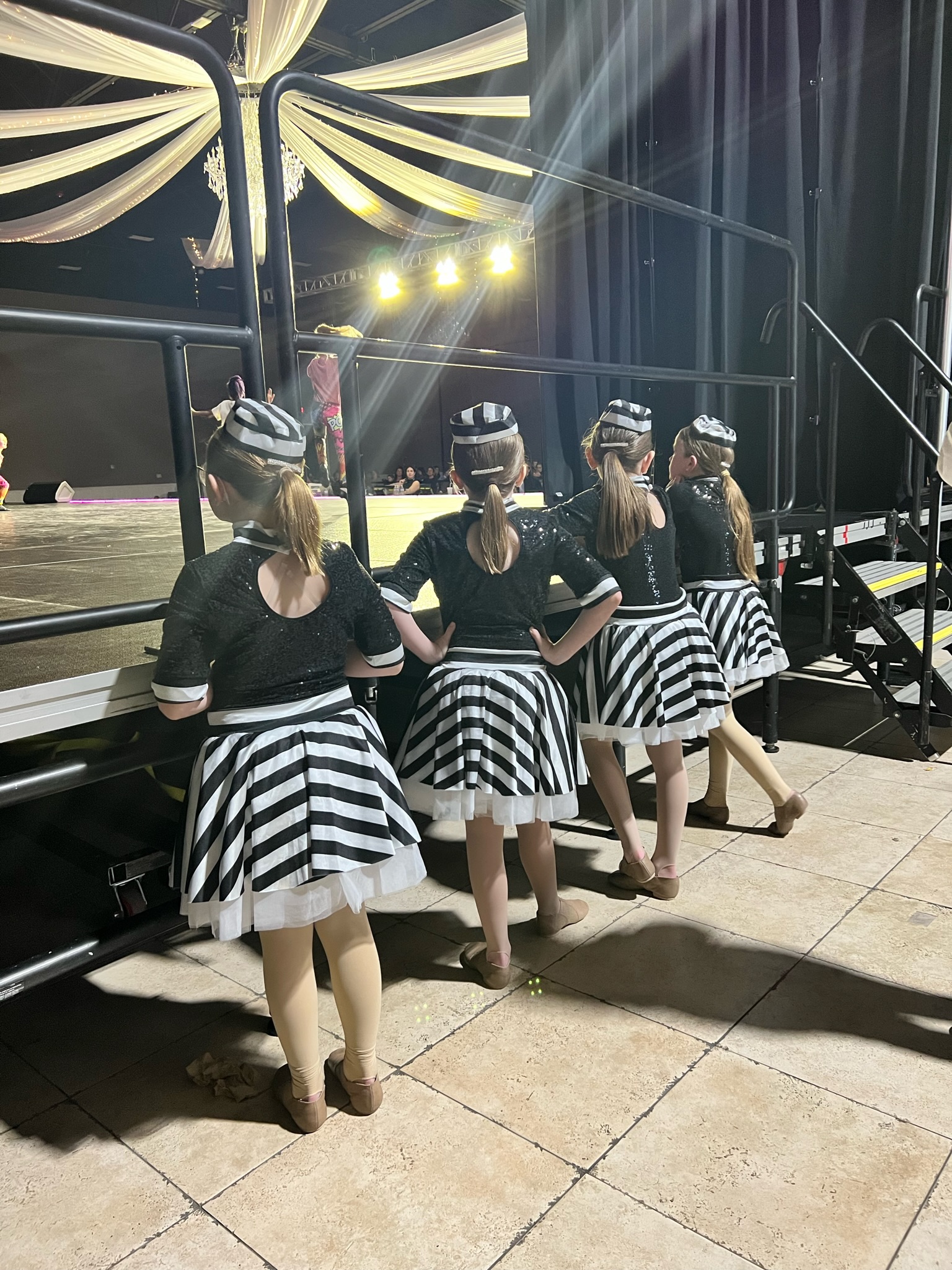 Dancers standing next to stage waiting to perform.