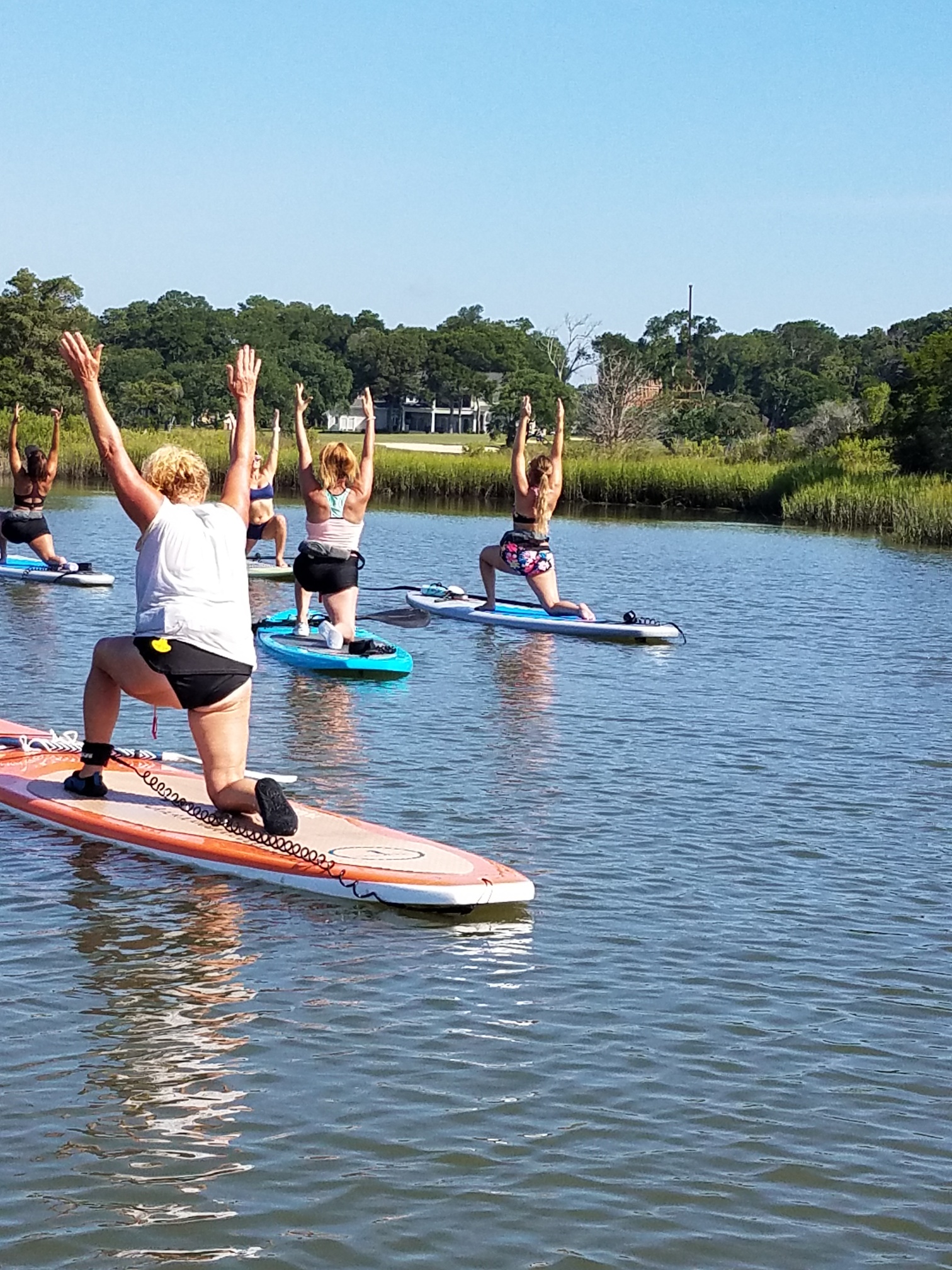 people on paddleboards doing yoga on the water
