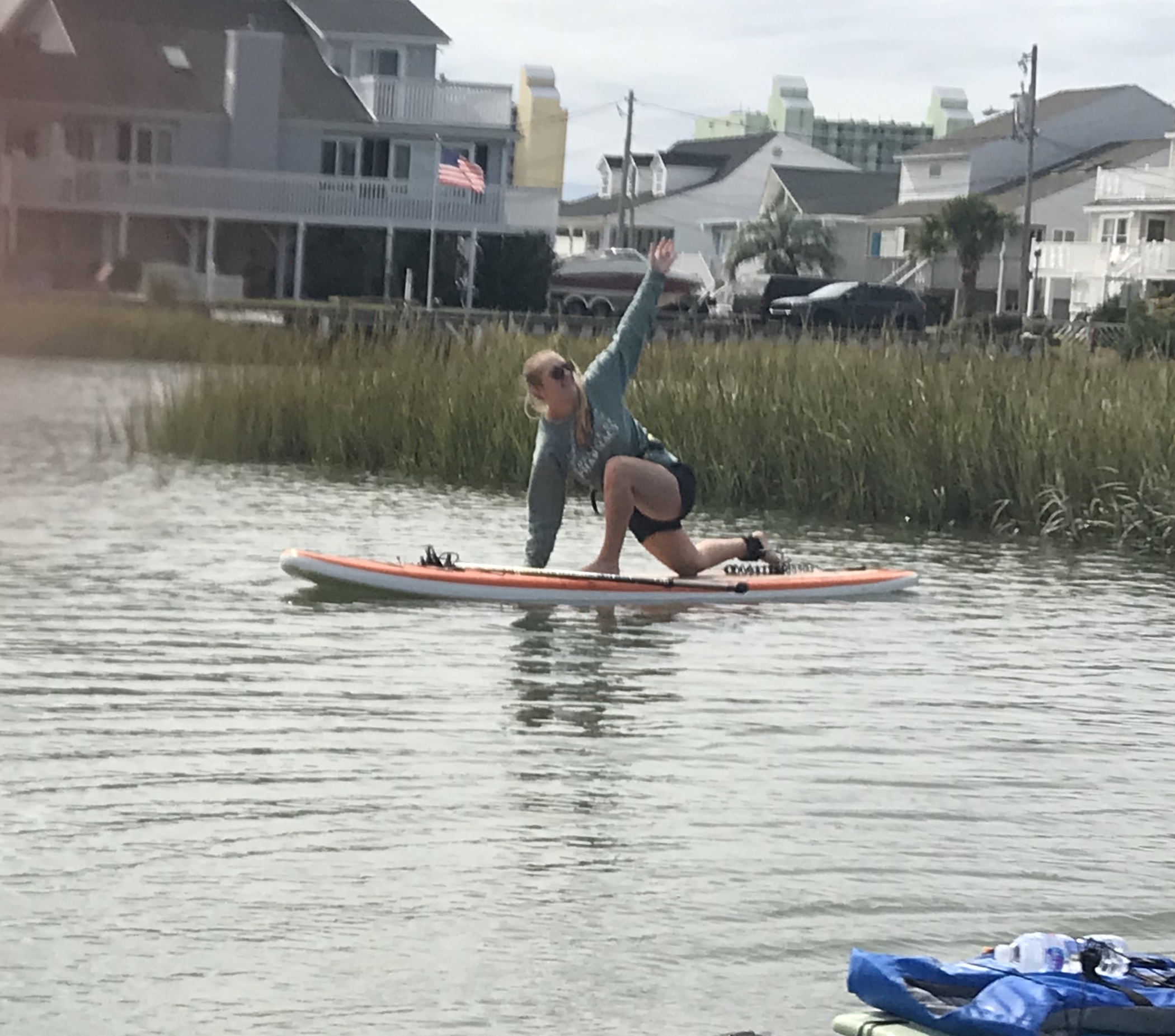 person doing yoga pose on a paddleboard in the water