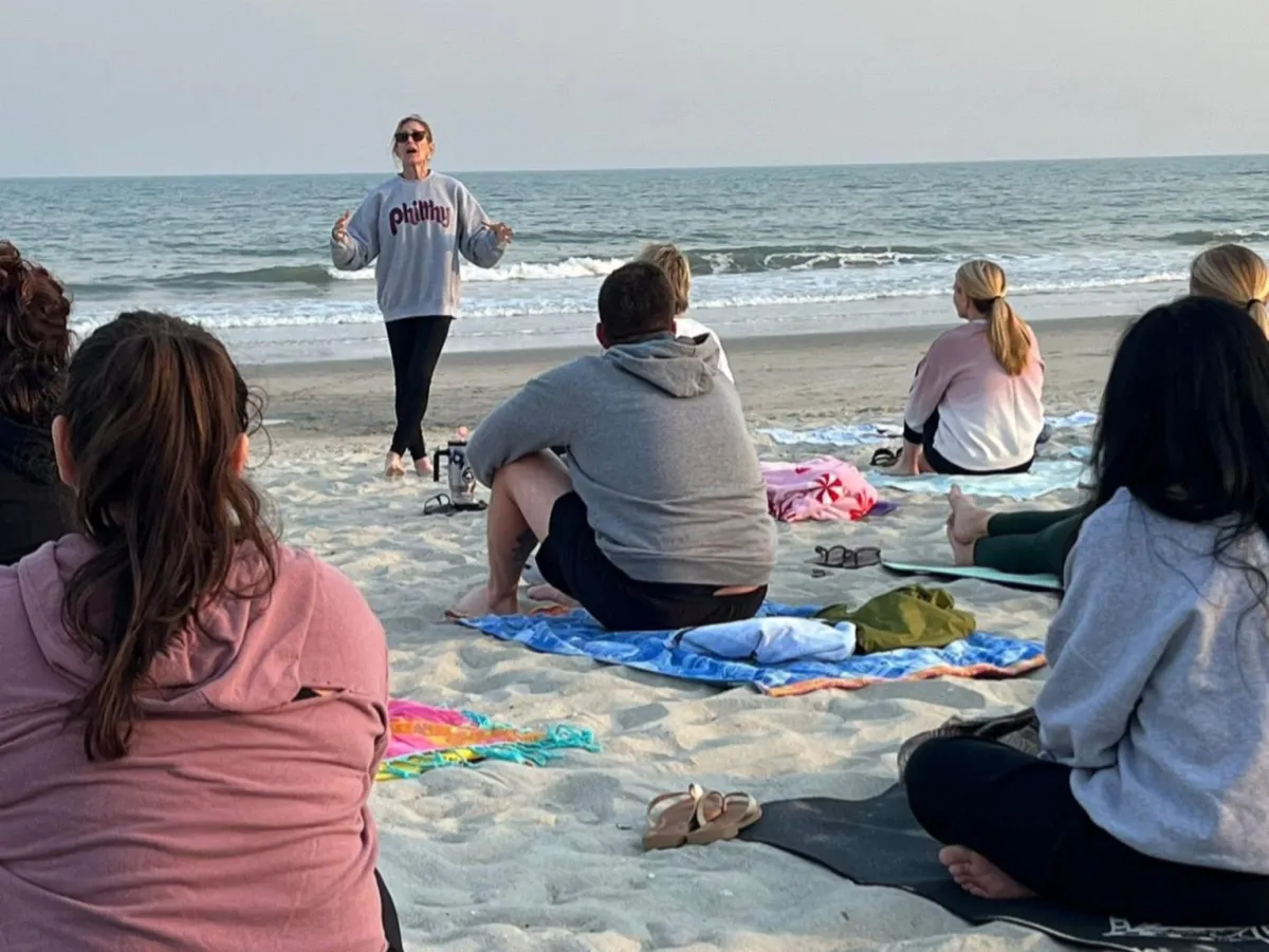 a woman kneeling on the beach 