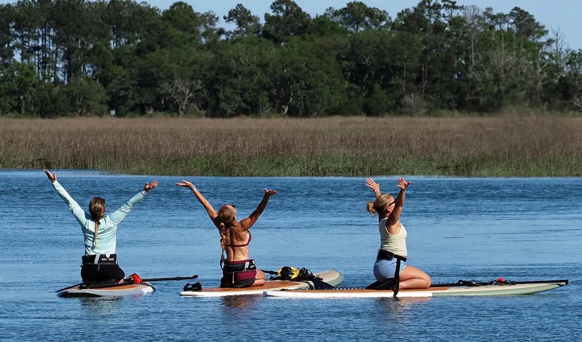 women doing paddleboard yoga
