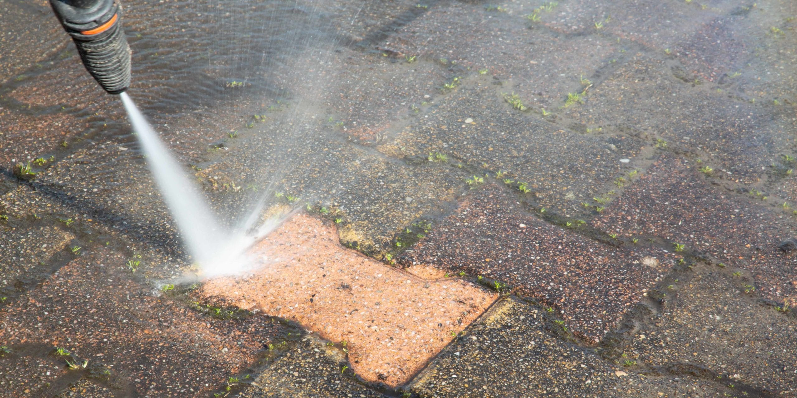 Patio pressure washing — before and after showing cleaned patio stones