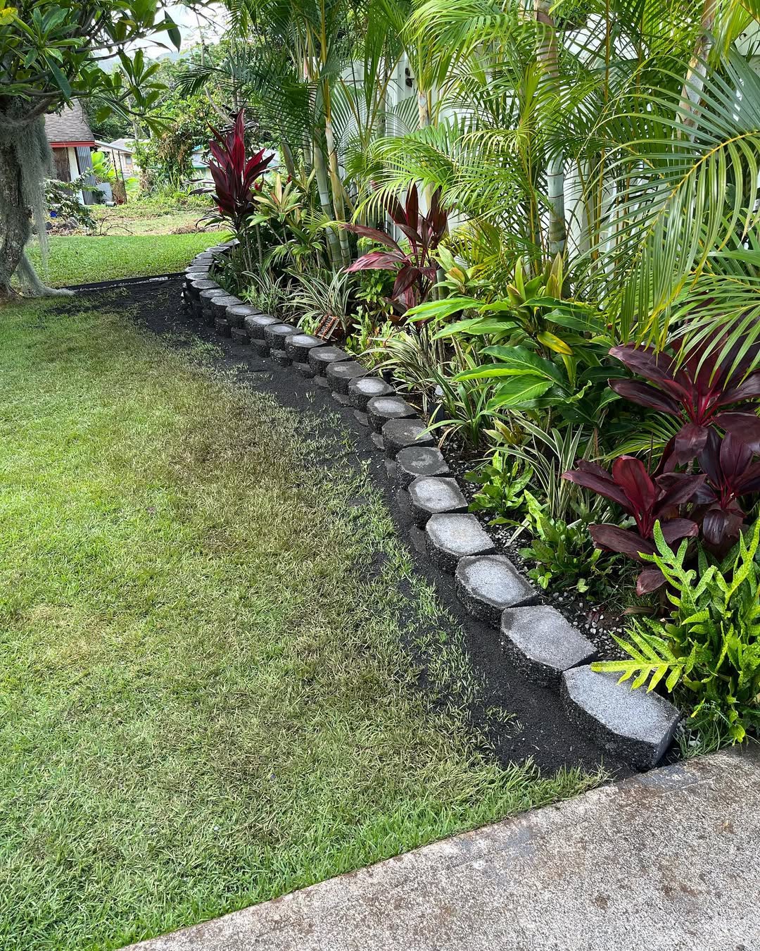 Custom tropical landscape design with stone garden borders and native planting in Kailua Oahu