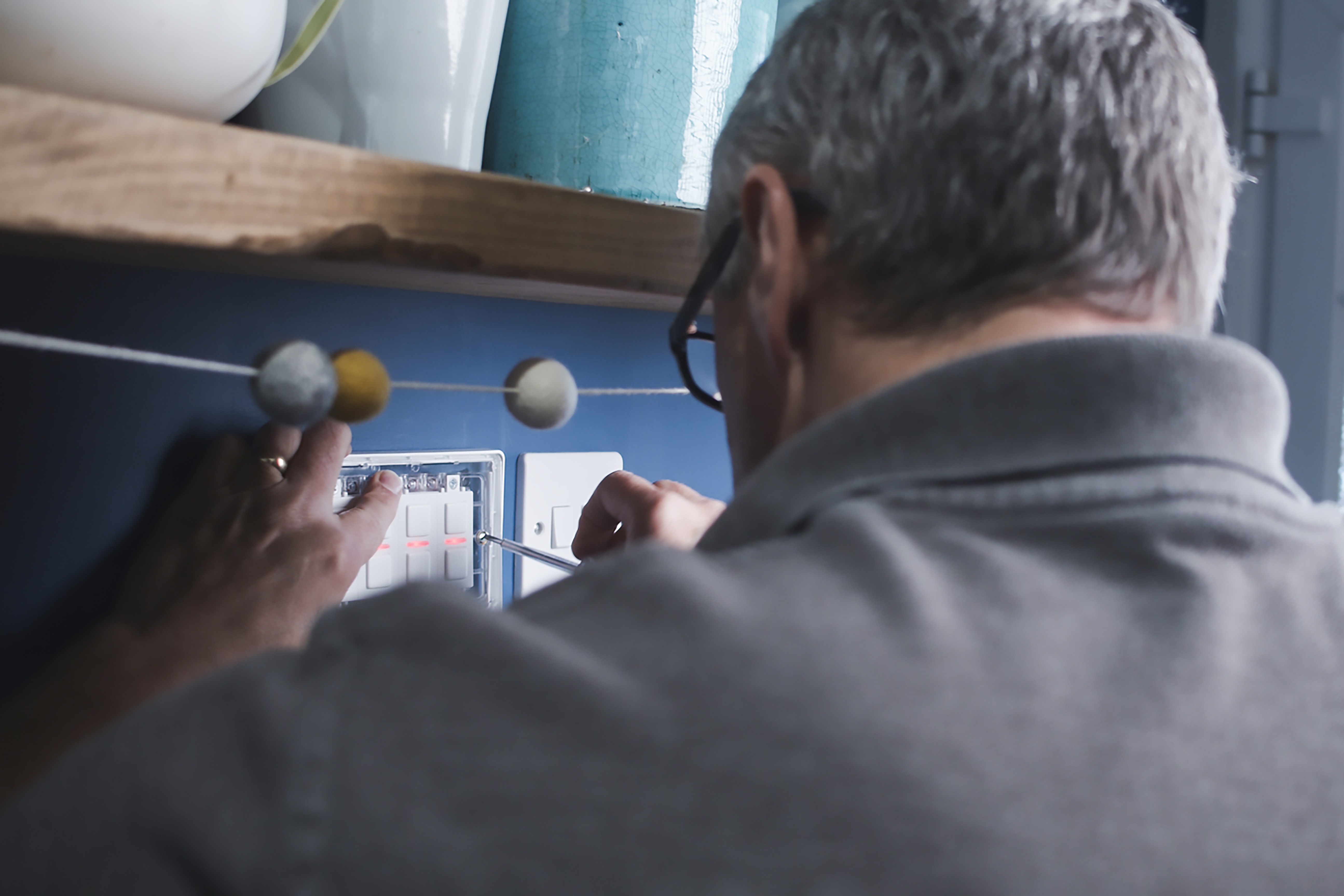 Electrician installing a LightwaveRF smart switch into an existing wall back box — retrofit installation using standard UK wiring
