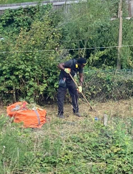 Worker from Garden Care Company tidying a garden